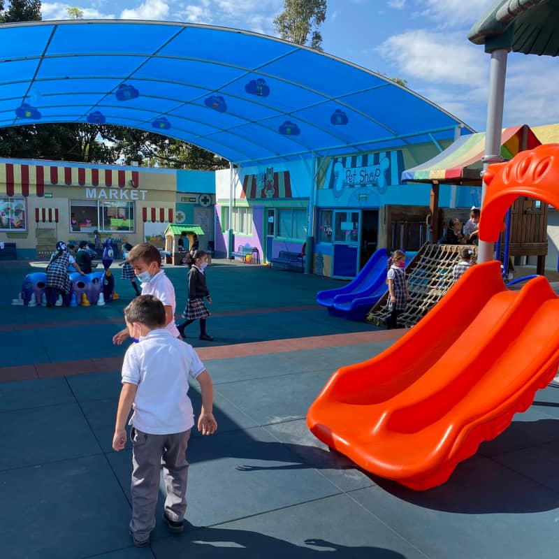Alumnos de primaria pasando el tiempo en patio de juegos del colegio.