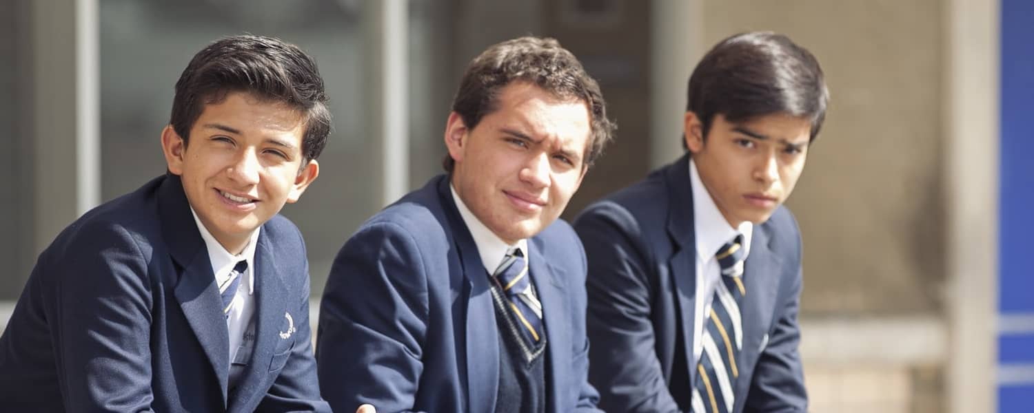 Tres alumnos de secundaria usando el uniforme . 