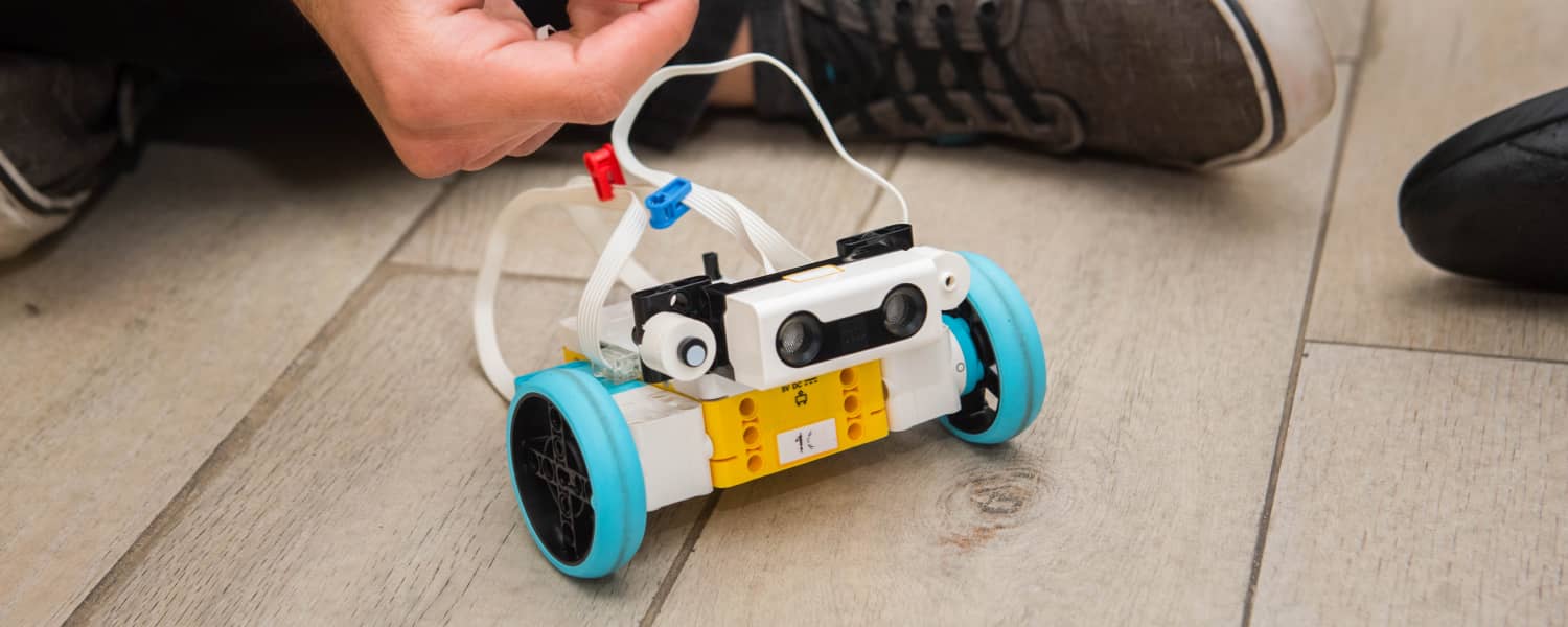 Robot de dos ruedas y un eje con dos sensores frontales realizando en Colegio Interamericano.