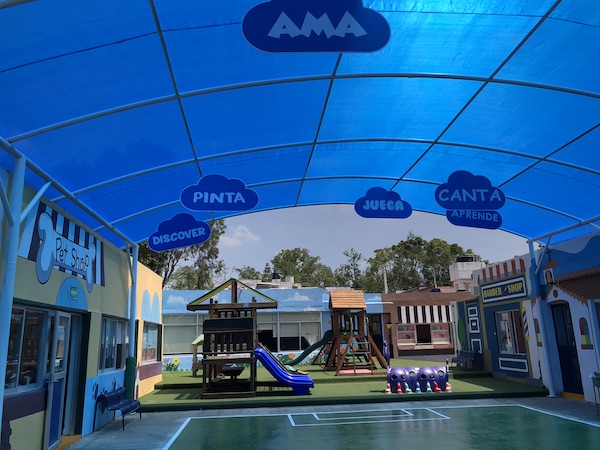 Patio de juegos con techo y juegos infantiles en Colegio Interamericano.